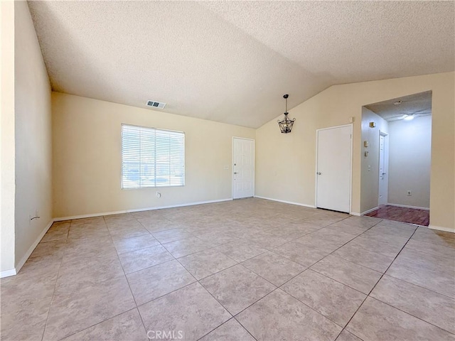 12967 Side Saddle Rd, Victorville, CA 92392 - empty room featuring a textured ceiling, light tile patterned flooring, lofted ceiling, and a chandelier