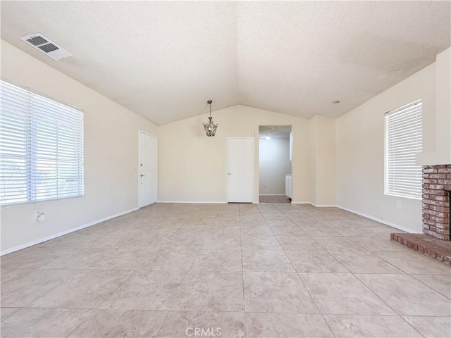 12967 Side Saddle Rd, Victorville, CA 92392 - unfurnished living room with a textured ceiling, vaulted ceiling, a brick fireplace, and light tile patterned flooring