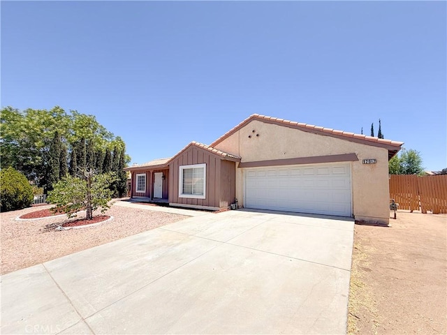 12967 Side Saddle Rd, Victorville, CA 92392 - ranch-style home with driveway, board and batten siding, and an attached garage