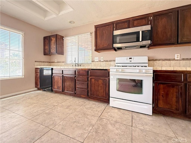 12967 Side Saddle Rd, Victorville, CA 92392 - kitchen featuring white gas stove, stainless steel microwave, dishwasher, and healthy amount of natural light
