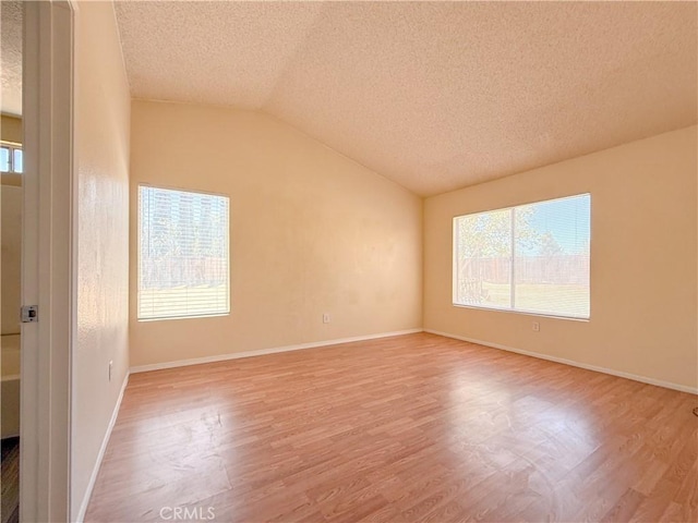 12967 Side Saddle Rd, Victorville, CA 92392 - spare room featuring a textured ceiling, lofted ceiling, and wood finished floors