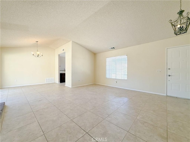 12967 Side Saddle Rd, Victorville, CA 92392 - spare room featuring a chandelier, light tile patterned flooring, vaulted ceiling, and a textured ceiling