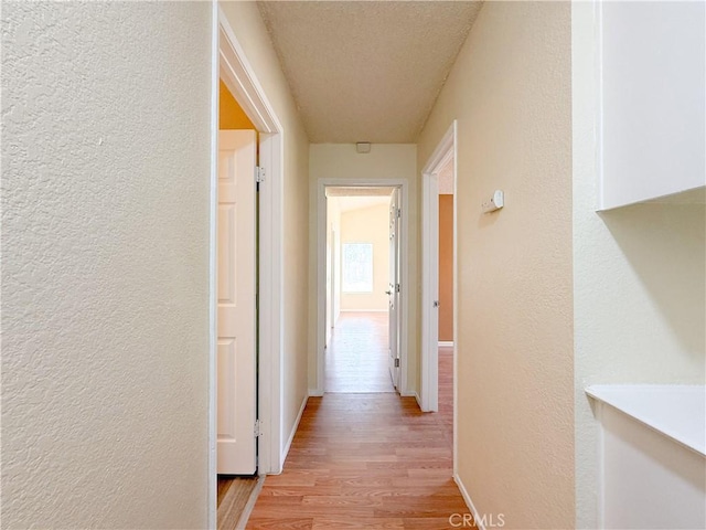 12967 Side Saddle Rd, Victorville, CA 92392 - hallway with a textured wall, light wood finished floors, and a textured ceiling