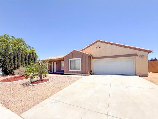 12967 Side Saddle Rd, Victorville, CA 92392 - ranch-style home featuring concrete driveway, a garage, and board and batten siding
