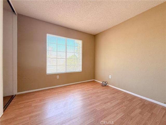 12967 Side Saddle Rd, Victorville, CA 92392 - spare room with light wood-type flooring and a textured ceiling