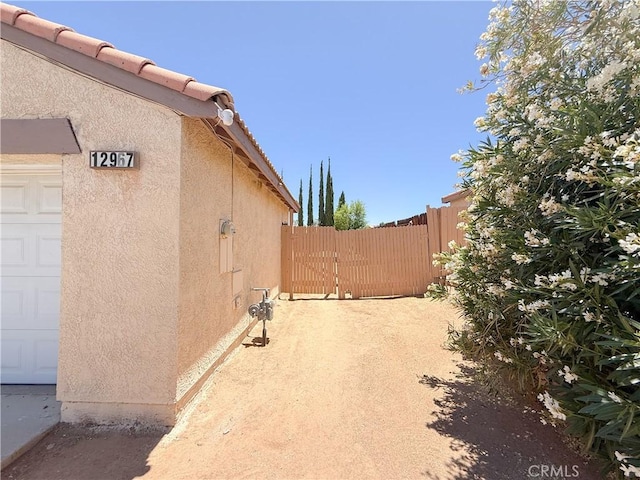 12967 Side Saddle Rd, Victorville, CA 92392 - view of side of property with stucco siding and a tile roof