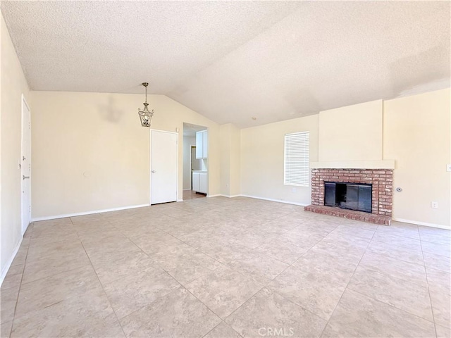 12967 Side Saddle Rd, Victorville, CA 92392 - unfurnished living room featuring lofted ceiling, a textured ceiling, a fireplace, and light tile patterned flooring
