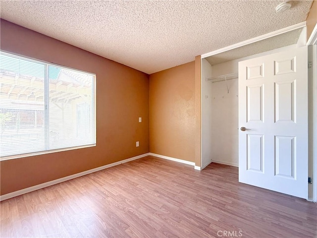 12967 Side Saddle Rd, Victorville, CA 92392 - unfurnished bedroom featuring wood finished floors, a textured ceiling, and a closet