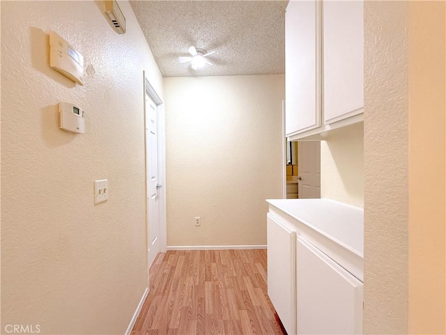 12967 Side Saddle Rd, Victorville, CA 92392 - hallway featuring light wood-style flooring, a textured ceiling, and a textured wall