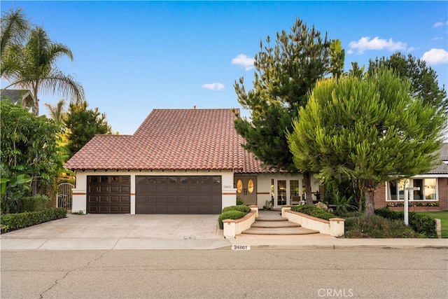 24861 Camberwell St, Laguna Hills, CA 92653 - view of front of house with an attached garage, concrete driveway, stucco siding, and a tile roof