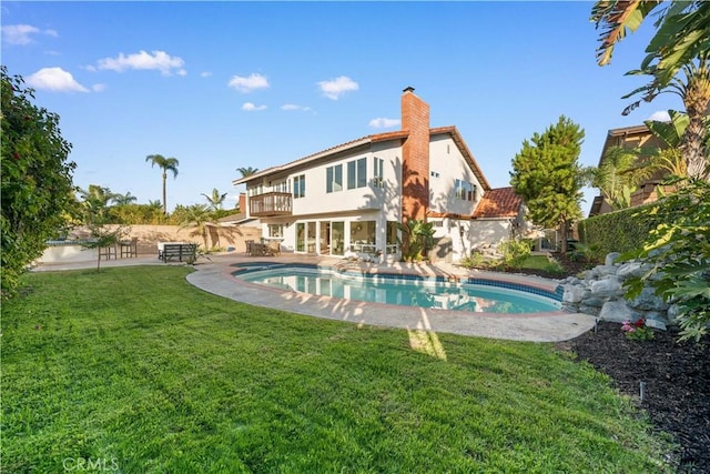 24861 Camberwell St, Laguna Hills, CA 92653 - back of house with a balcony, stucco siding, a yard, a patio area, and a chimney