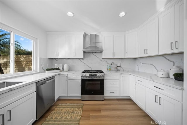 24861 Camberwell St, Laguna Hills, CA 92653 - kitchen with wall chimney range hood, appliances with stainless steel finishes, white cabinets, recessed lighting, and backsplash