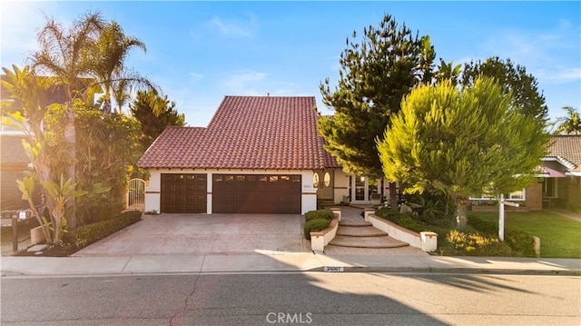 24861 Camberwell St, Laguna Hills, CA 92653 - view of front of home with driveway, a garage, stucco siding, and a tiled roof