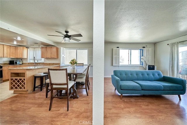 2424 S Gaffey St Unit 101, San Pedro, CA 90731 - dining area with a textured ceiling, light wood-style flooring, and ceiling fan