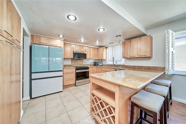 2424 S Gaffey St Unit 101, San Pedro, CA 90731 - kitchen with appliances with stainless steel finishes, light brown cabinets, a peninsula, plenty of natural light, and recessed lighting