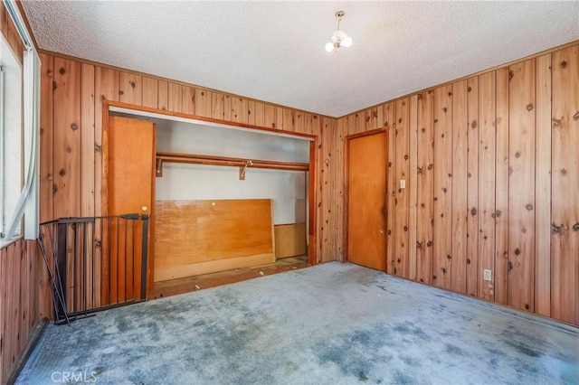 2439 California St, Walnut Park, CA 90255 - unfurnished bedroom with carpet flooring, a textured ceiling, a closet, and wooden walls