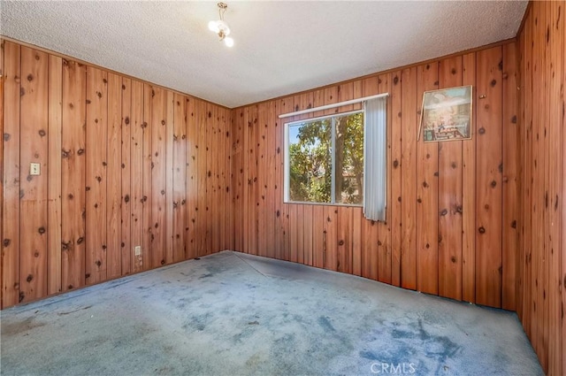 2439 California St, Walnut Park, CA 90255 - carpeted empty room with a textured ceiling and wooden walls