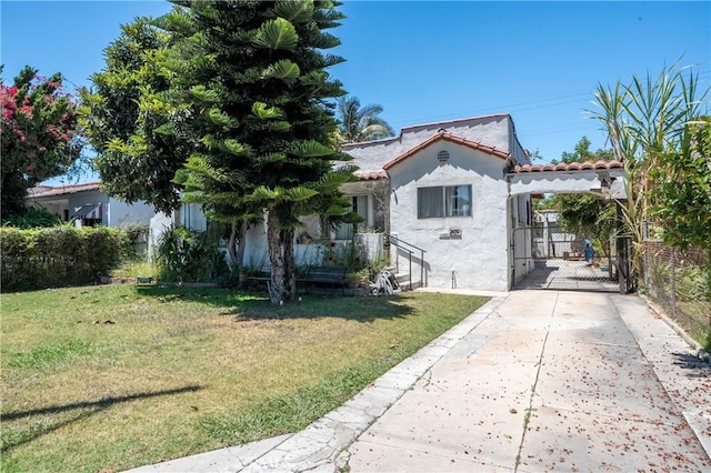 2439 California St, Walnut Park, CA 90255 - view of front facade featuring driveway, a front yard, stucco siding, a tiled roof, and a gate