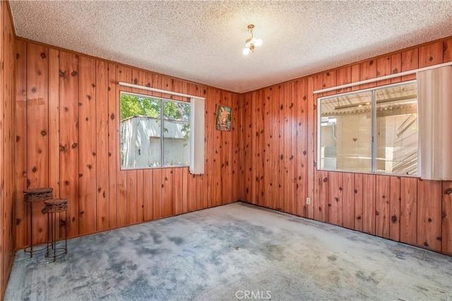2439 California St, Walnut Park, CA 90255 - carpeted empty room featuring wood walls and a textured ceiling