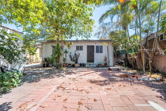 2439 California St, Walnut Park, CA 90255 - rear view of property with stucco siding, entry steps, and a patio