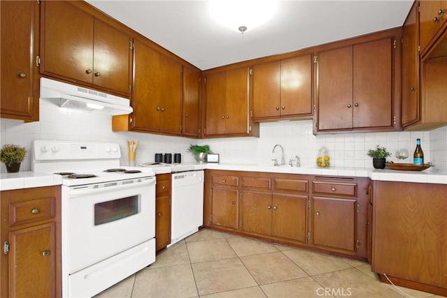 545 Chestnut Ave Unit 411, Long Beach, CA 90802 - kitchen with white appliances, under cabinet range hood, tasteful backsplash, light tile patterned floors, and brown cabinets