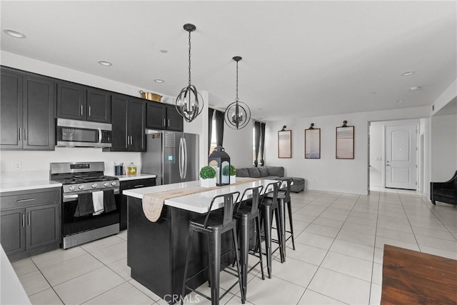 4443 Manzanita St, Guadalupe, CA 93434 - kitchen featuring stainless steel appliances, open floor plan, light countertops, light tile patterned floors, and dark cabinets