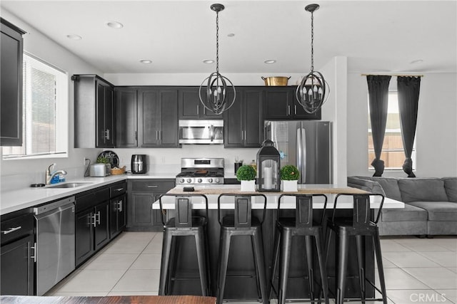 4443 Manzanita St, Guadalupe, CA 93434 - kitchen featuring appliances with stainless steel finishes, light tile patterned floors, a kitchen bar, healthy amount of natural light, and recessed lighting