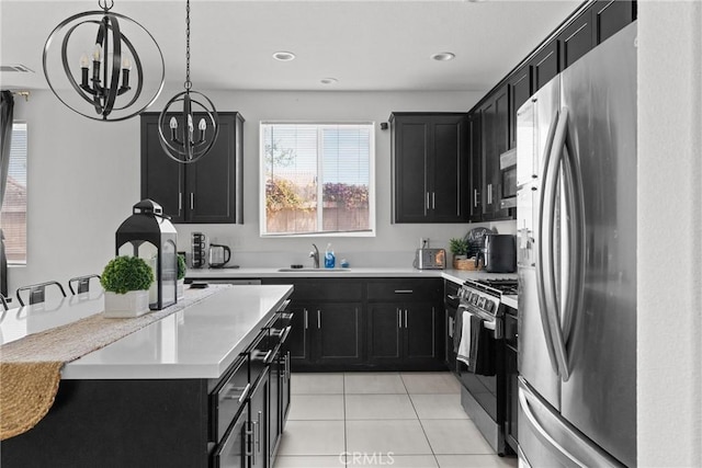 4443 Manzanita St, Guadalupe, CA 93434 - kitchen featuring appliances with stainless steel finishes, dark cabinets, light tile patterned floors, a chandelier, and recessed lighting
