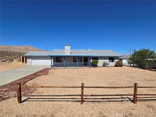7050 Ivanpah Ave Unit 29, Palms, CA 92277 - ranch-style home featuring concrete driveway, an attached garage, and a chimney