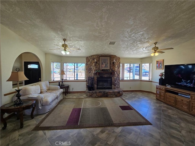 7050 Ivanpah Ave Unit 29, Palms, CA 92277 - living area featuring a ceiling fan, plenty of natural light, a textured ceiling, and a stone fireplace
