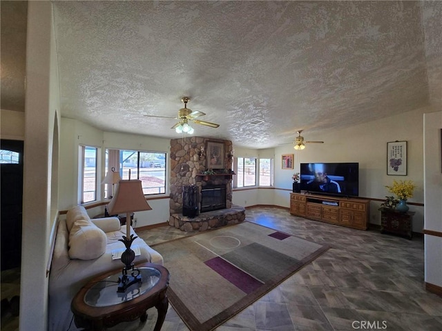 7050 Ivanpah Ave Unit 29, Palms, CA 92277 - living area featuring ceiling fan, a stone fireplace, and a textured ceiling