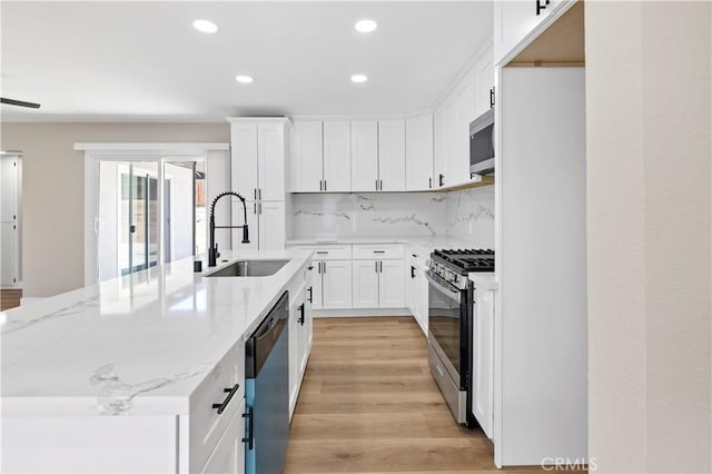 7364 Layton St, Rancho Cucamonga, CA 91730 - kitchen with appliances with stainless steel finishes, a kitchen island with sink, recessed lighting, white cabinetry, and light wood-style flooring