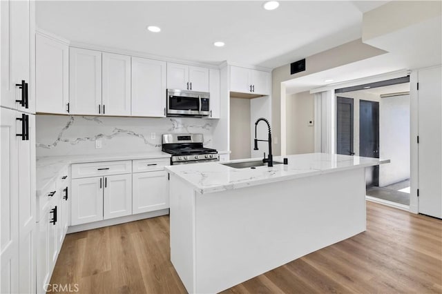 7364 Layton St, Rancho Cucamonga, CA 91730 - kitchen with appliances with stainless steel finishes, white cabinets, light stone counters, light wood finished floors, and recessed lighting