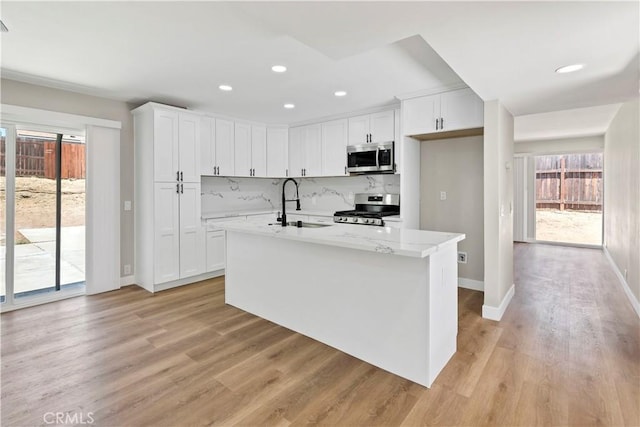 7364 Layton St, Rancho Cucamonga, CA 91730 - kitchen with appliances with stainless steel finishes, white cabinets, light wood finished floors, recessed lighting, and backsplash