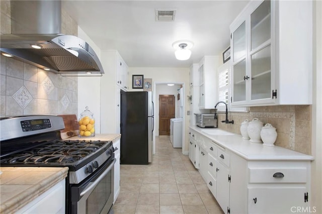 829 N Foxdale Ave, West Covina, CA 91790 - kitchen with stainless steel appliances, island exhaust hood, washer / clothes dryer, light countertops, and white cabinetry