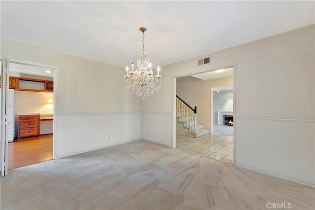 1318 Sao Paulo Ave, Placentia, CA 92870 - unfurnished room with a chandelier, stairway, carpet flooring, and a warm lit fireplace