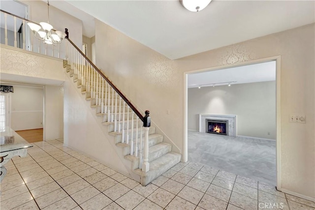 1318 Sao Paulo Ave, Placentia, CA 92870 - stairs featuring tile patterned floors, a chandelier, a lit fireplace, and rail lighting