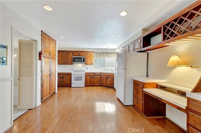 1318 Sao Paulo Ave, Placentia, CA 92870 - kitchen featuring white appliances, open shelves, light wood-type flooring, brown cabinetry, and built in study area
