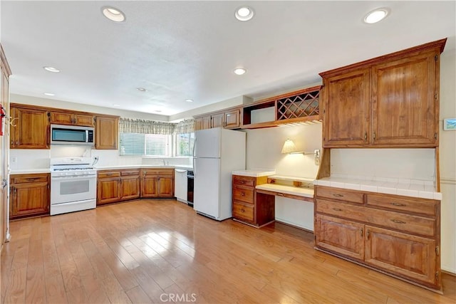 1318 Sao Paulo Ave, Placentia, CA 92870 - kitchen with white appliances, built in study area, brown cabinetry, open shelves, and recessed lighting