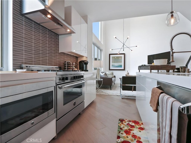 4405 Channel Pl, Newport Beach, CA 92663 - kitchen with range hood, stainless steel appliances, white cabinets, and modern cabinets