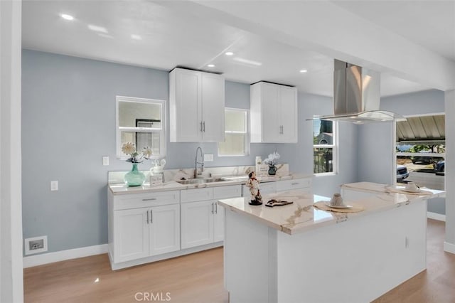 2049 W 71st St, Los Angeles, CA 90047 - kitchen with light wood-type flooring, island exhaust hood, white cabinetry, a center island, and recessed lighting