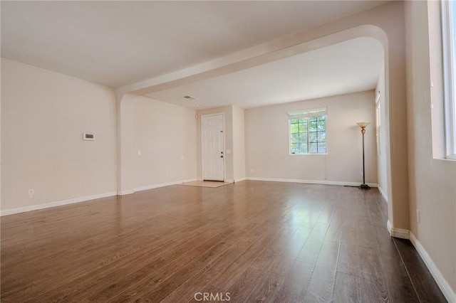 11818 Forest Park Ln, Victorville, CA 92392 - unfurnished living room with dark wood-style floors and arched walkways