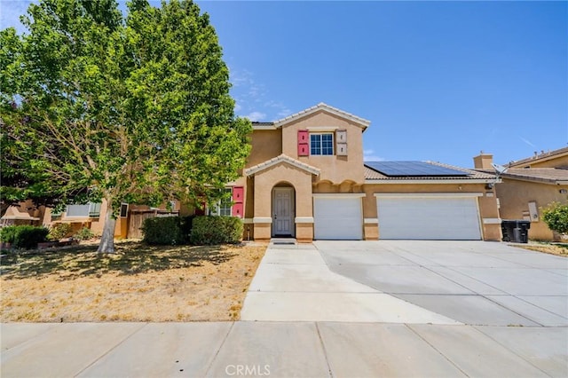 11818 Forest Park Ln, Victorville, CA 92392 - mediterranean / spanish home featuring solar panels, stucco siding, driveway, a garage, and a tiled roof