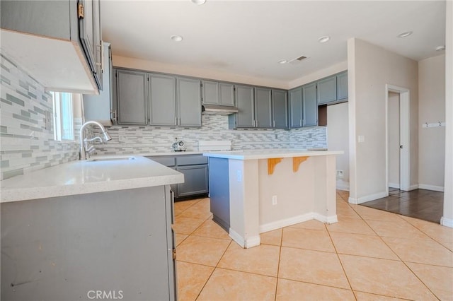 11818 Forest Park Ln, Victorville, CA 92392 - kitchen with tasteful backsplash, light tile patterned floors, light countertops, gray cabinets, and recessed lighting