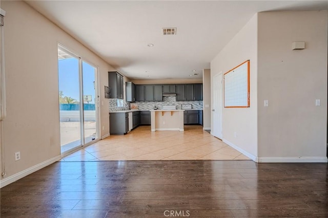 11818 Forest Park Ln, Victorville, CA 92392 - kitchen with light countertops, decorative backsplash, gray cabinetry, light wood finished floors, and open floor plan