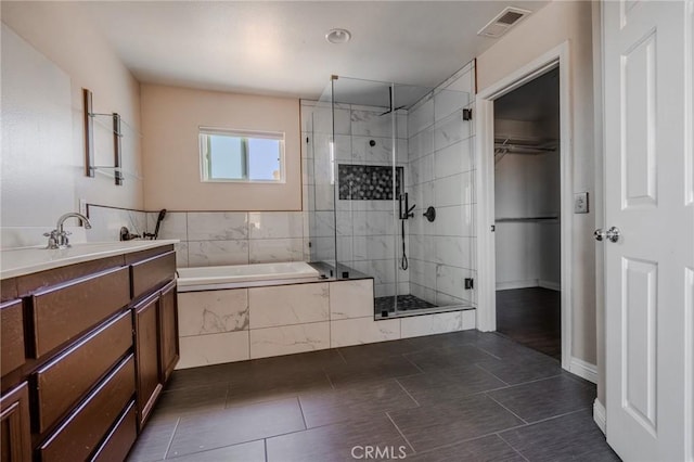 11818 Forest Park Ln, Victorville, CA 92392 - bathroom with a stall shower, a bath, a spacious closet, vanity, and tile patterned flooring