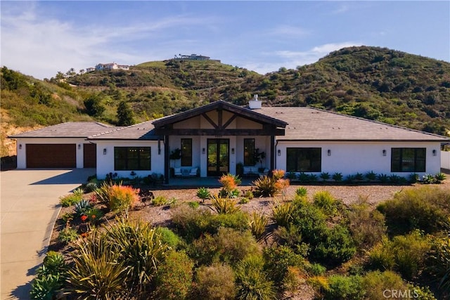 3325 Sagewood Hills Rd, Vista, CA 92084 - view of front of property featuring french doors, a mountain view, a garage, concrete driveway, and stucco siding