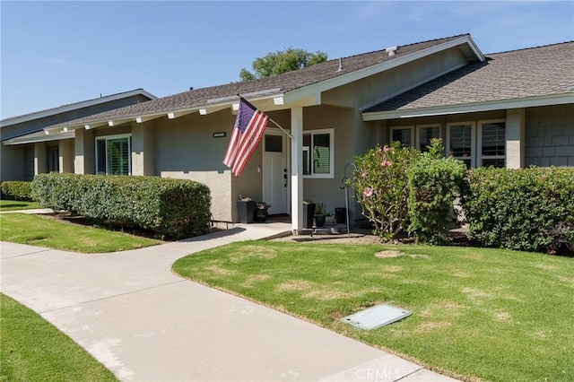 8645 Butte Cir Unit 603C, Huntington Beach, CA 92646 - view of front of house with a front yard, roof with shingles, and stucco siding