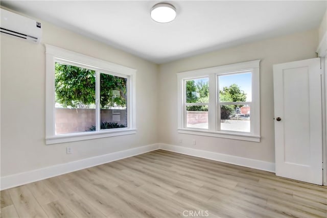 293 E Congress St, Colton, CA 92324 - empty room featuring a wall unit AC, plenty of natural light, and light wood finished floors