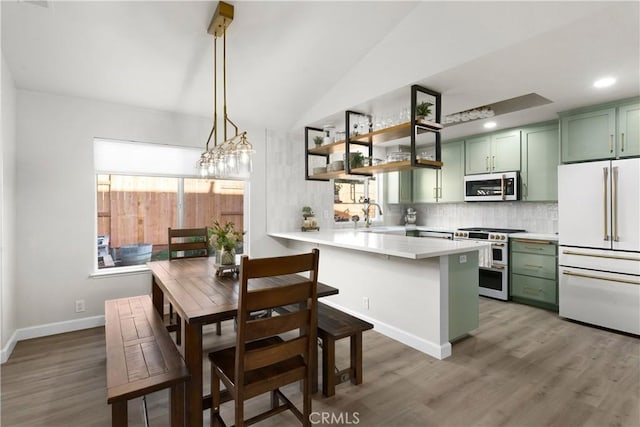1101 Admiral Ln, Chico, CA 95973 - kitchen featuring green cabinetry, white appliances, a peninsula, decorative backsplash, and light wood-type flooring